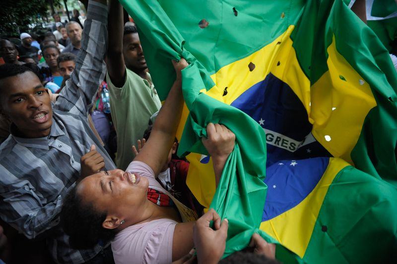 A bandeira do Brasil com buracos simulando balas foi levada também no enterro dos cinco jovens, em dezembro do ano passado (Foto: Fernando Frazão/Agência Brasil) 